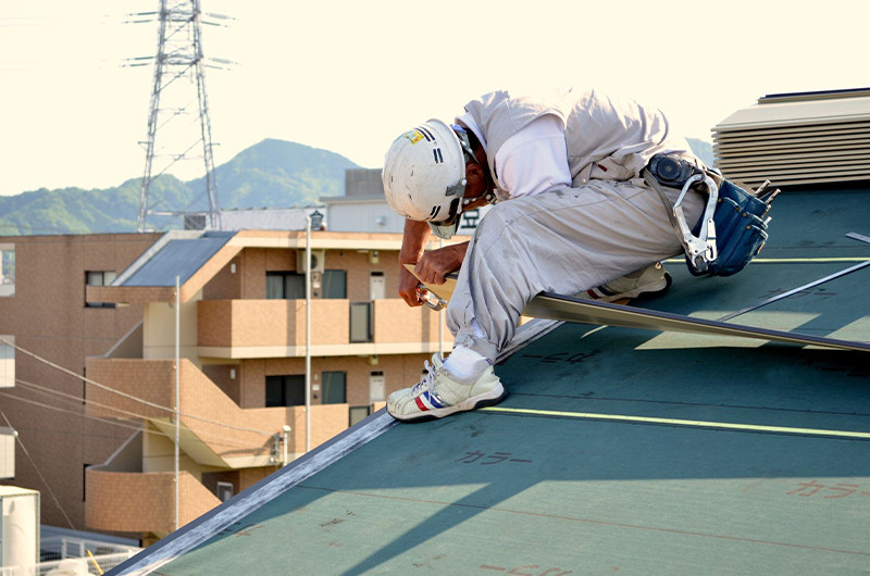 屋根に上って作業している人